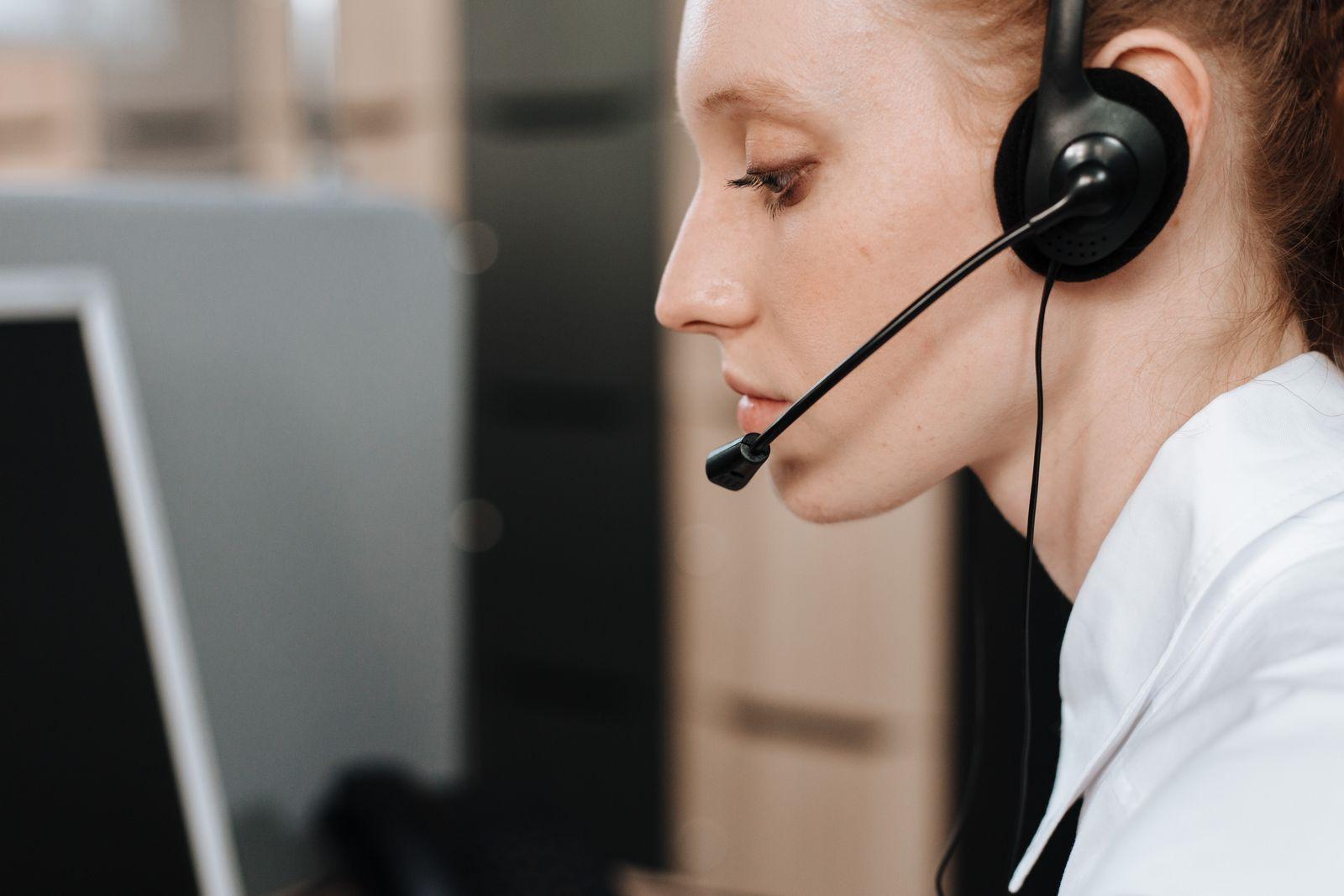 A customer support agent wearing a headset while working at a desk