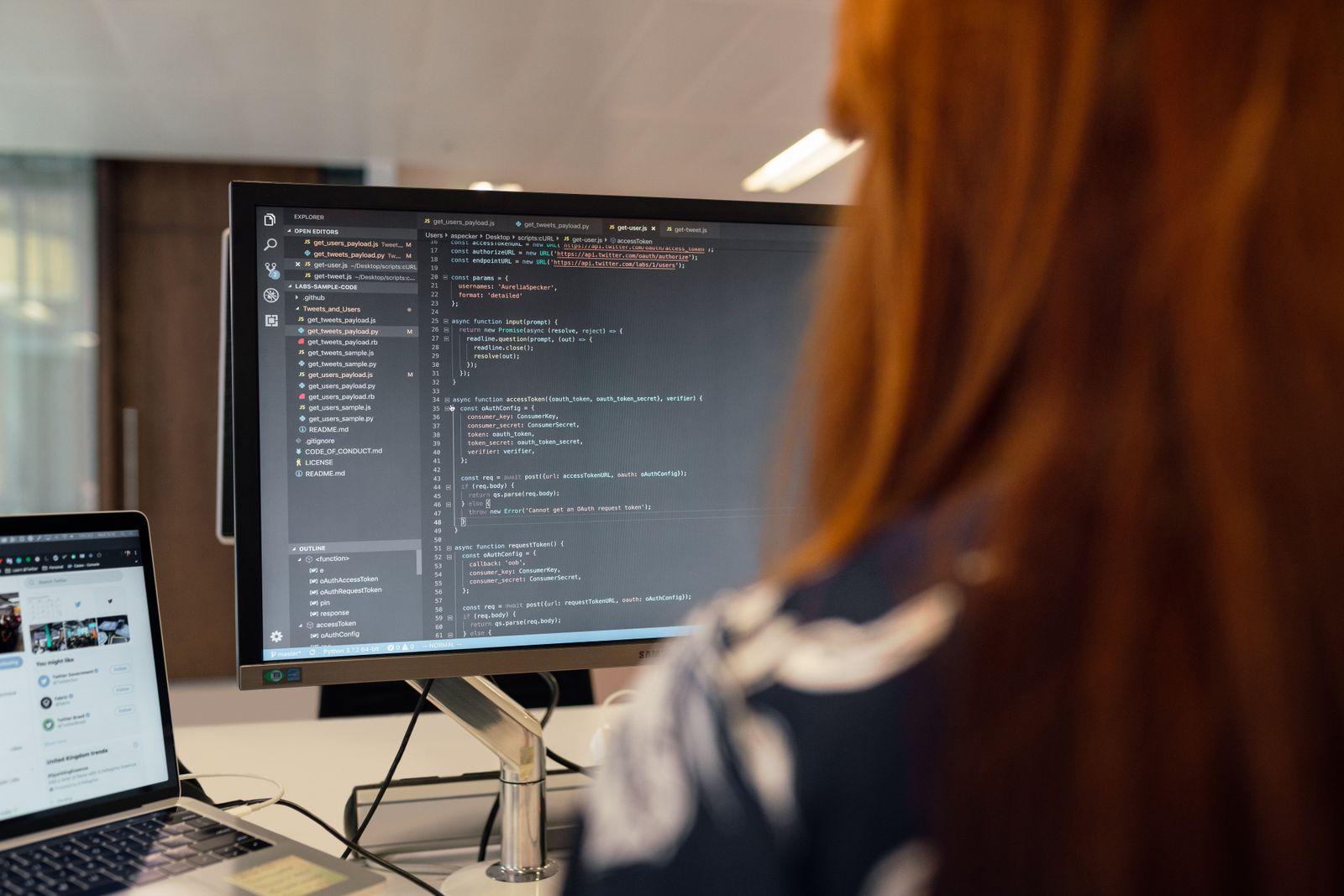 A software engineer working through code on screen in an office